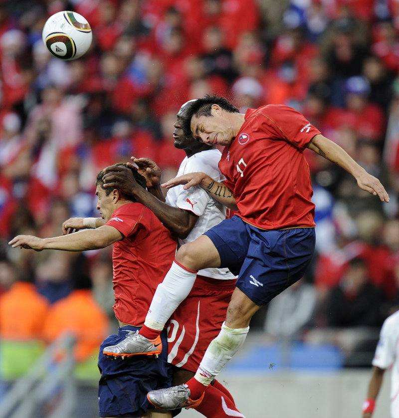 Chilean teammates Carlos Carmona, left, and Gary Medel, right, fight for the ball with Switzerland’s Blaise Nkufo on Monday in Port Elizabeth, South Africa. Chile won, 1-0.