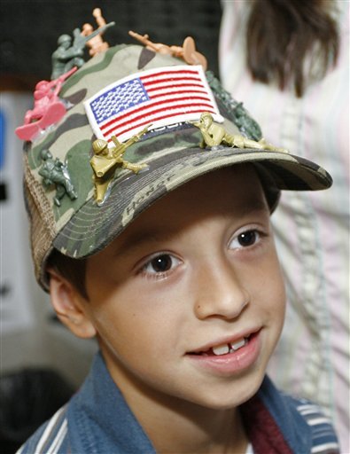David Morales models the hat decorated with toy soldiers that got him in trouble in school.
