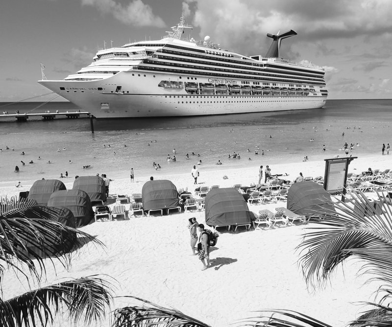 CARNIVAL PROFIT DIPS: Passengers aboard the Carnival Destiny relax on the beach at the Grand Turk Cruise Terminal in the Turks and Caicos Islands. A 64 percent increase in fuel prices hurt Carnival Corp.'s second-quarter net income, which fell more than 4 percent to $252 million.
