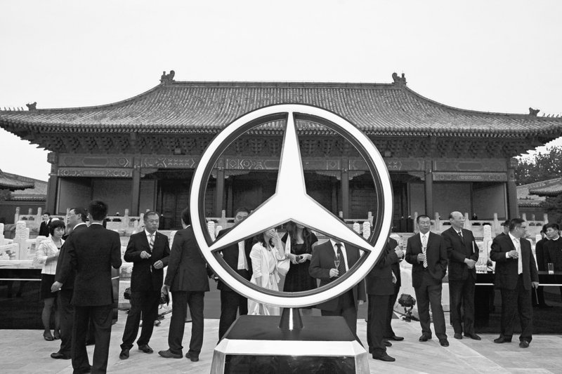 Guests stand next to a large Mercedes Benz logo at the launch of the automaker's S Class in Beijing last year.