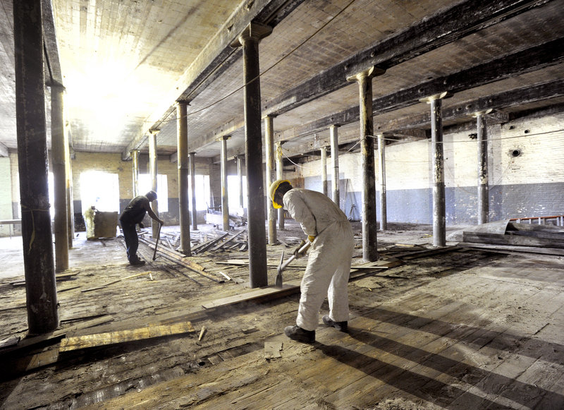 A work crew removes old flooring at the former Bates Mill in Lewiston, soon to be the home of Baxter Brewing Co.
