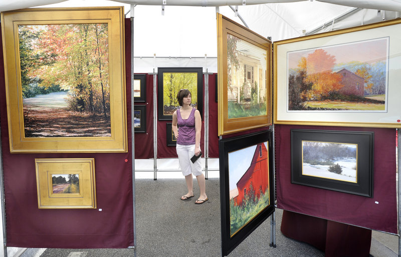 Angela Dupuis of Saco wanders through a display of paintings by Stephen Previte, an artist from Hollis, N.H.