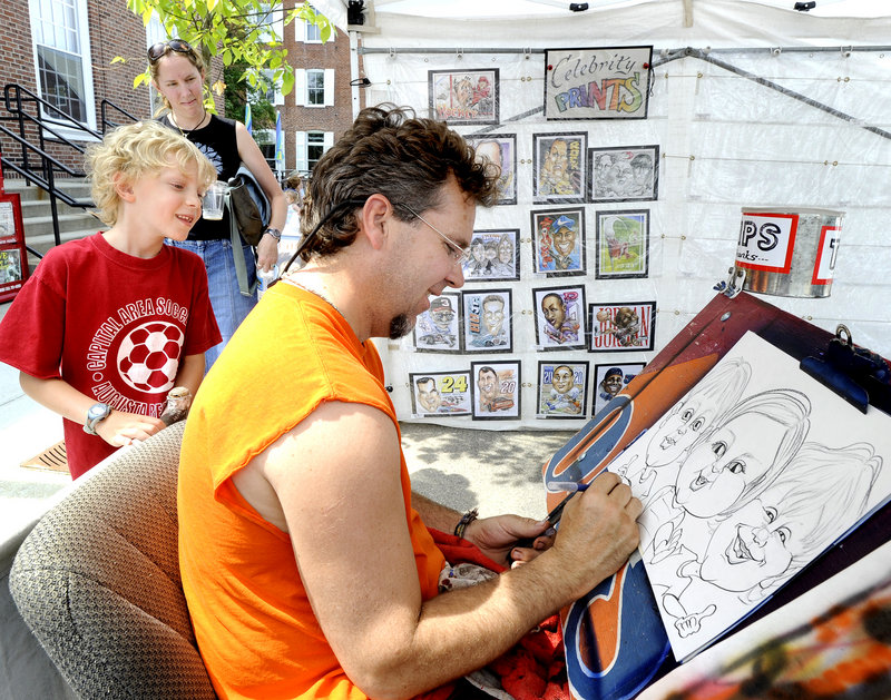 Eight-year-old Blaise Kiely and his mother, Heather Kiely, of Biddeford watch caricature artist Ken Crouse draw Blaise and his younger brother and sister.