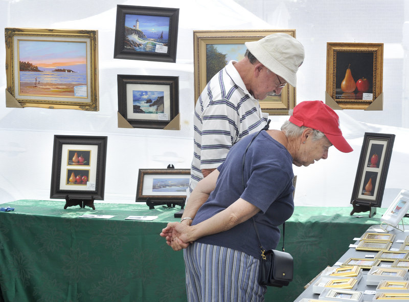 Bob and Priscilla Kelley of Saco examine some of the smaller pieces of artwork at the Saco Spirit Art Festival.