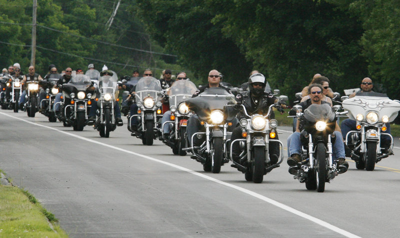 Members of the Outlaws motorcycle club, joined by members from other clubs, ride through Hollis Center on Saturday on their way to a memorial service for Thomas Mayne, a club leader who was killed June 15 during a shootout with federal agents in Old Orchard Beach.