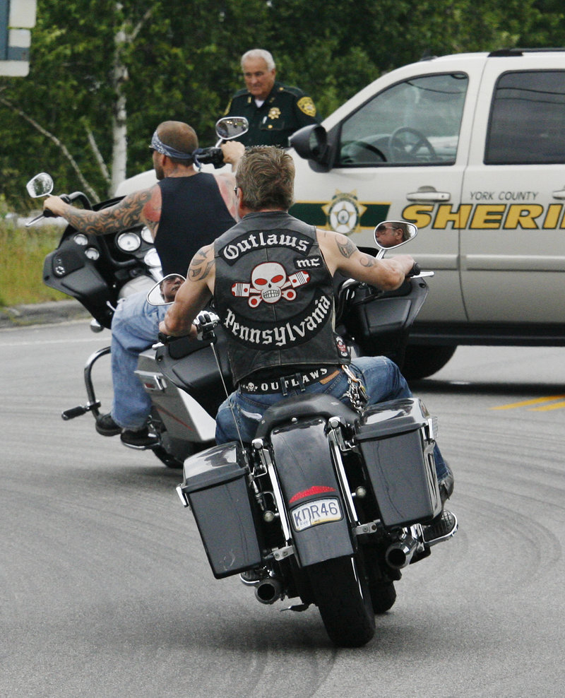 Members of the Outlaws motorcycle club pass a roadblock as they ride through Hollis Center Saturday. Club members gathered for a memorial service for Thomas Mayne, a club leader who was killed during a shootout with federal agents on June 15 after ATF agents tried to arrest him at his home in Old Orchard Beach.