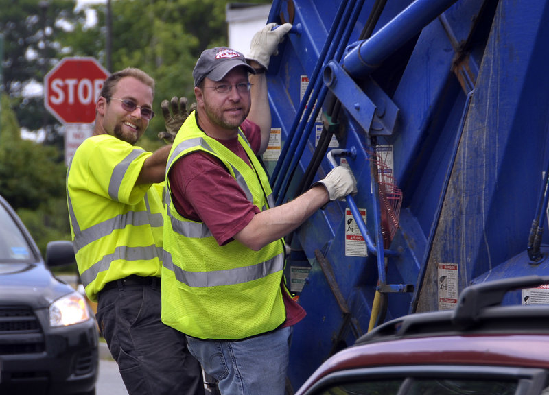 Staff Writer Ray Routhier, right, rides a garbage truck Thursday with Nick Albano, a Portland trash collector.