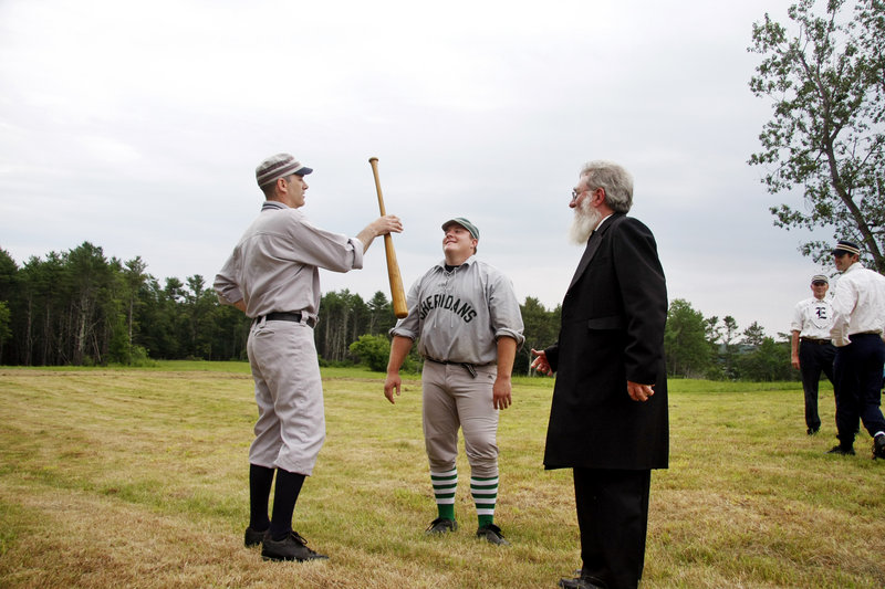 Umpire Jeff “Gray Beard” Peart of Manchester, Mass., right, watches as Mark “Limelight” Rochman of Augusta, left, wins the bat toss for Dirigo over Brian “Cappy” Sheehy of Methuen, Mass., to decide first-ups.