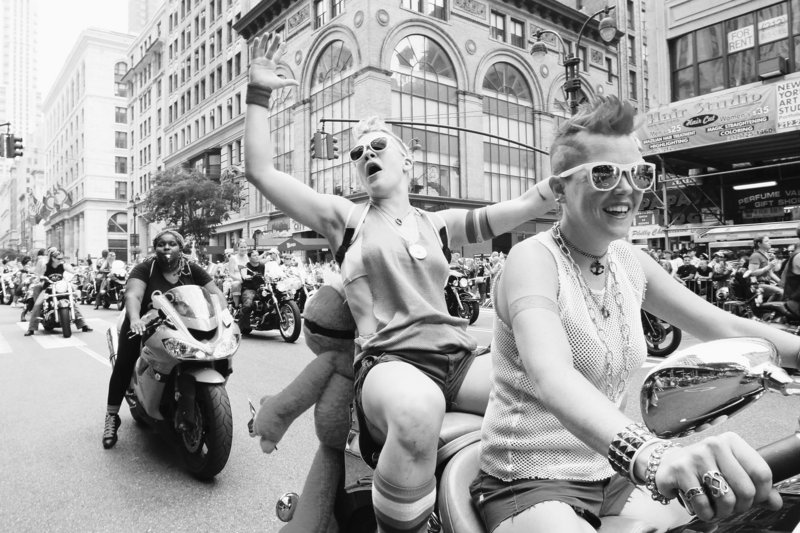 Jackie Carlson, second from right, and her partner, Cara Lee Sparry, both of Brooklyn, N.Y., make their way down New York’s Fifth Avenue as they take part in the annual gay pride parade Sunday. San Francisco’s celebration was marred by a fatal shooting at a street party.