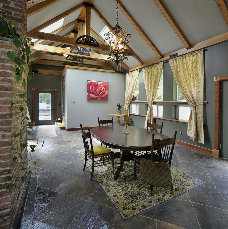 The dining room boasts a cathedral ceiling, wooden beams, skylights and a slate floor.