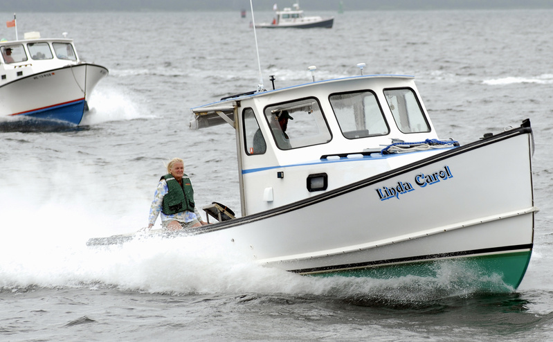 Linda Smith sits tight as the Linda Carol races to victory in the Gasoline Class B race during the recent lobster boat series event in Searsport. The boat, operated by Chris and Linda Smith, also finished second in the Gasoline Free for All. Lobster boat racing can be described as a block party on water.