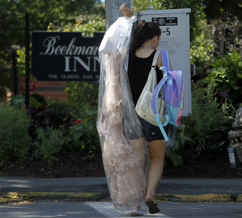 A woman carries a gown outside the Beekman Arms Inn in Rhinebeck, N.Y., today. Chelsea Clinton and fiance Marc Mezvinsky are expected to be married in Rhinebeck tonight.