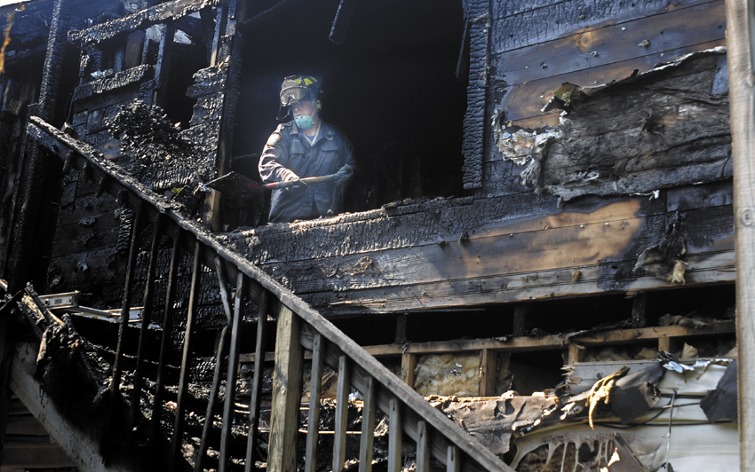 A state Fire Marshal's Office investigator shovels coals from a burned apartment Tuesday at 75 Second Street in Hallowell. An early-morning fire heavily damaged the multi-unit building. The cause of the fire, according to Hallowell Fire Chief Mike Grant, remains under investigation.