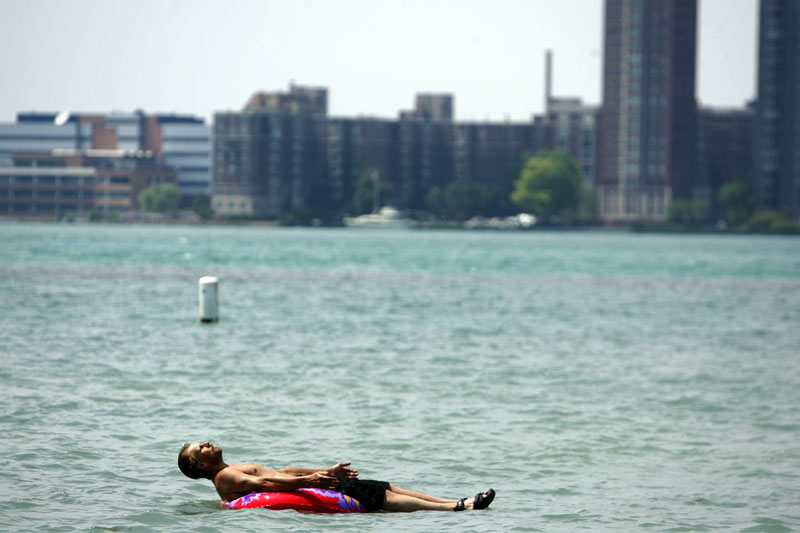 Stefan Sidorowicz, 43, of Hamtramck, Mich., floats along the Detroit River off Belle Isle as temperatures climbed above the mid-'90s in Detroit on Monday.