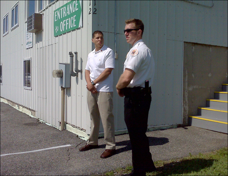 A pair of Secret Service agents wait by the entrance to the private hangar at the Hancock County-Bar Harbor Airport in Trenton that is expected to be used by the first family.