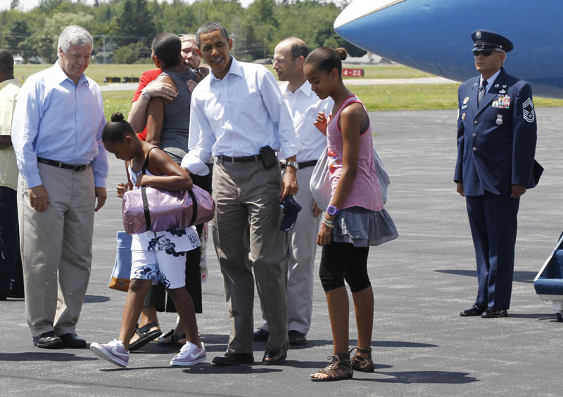 President Barack Obama with daughters Sasha and Malia after they were greeted by Maine Gov. John Baldacci, rear, center, Maine First Lady Karen Baldacci, hugging first lady Michelle Obama, rear, and Rep. Mike Michaud, D-Maine, at Hancock County Bar Harbor Airport in Trenton today.