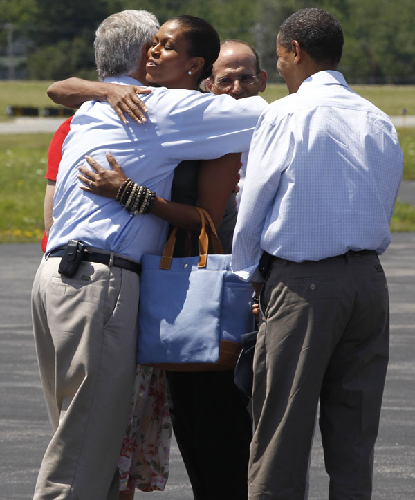 First lady Michelle Obama hugs Rep. Mike Michaud, D-Maine, as he and President Barack Obama are greeted by Maine Gov. John Baldacci.