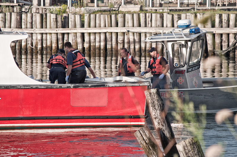 Portland firefighters recover a body from the harbor this morning.