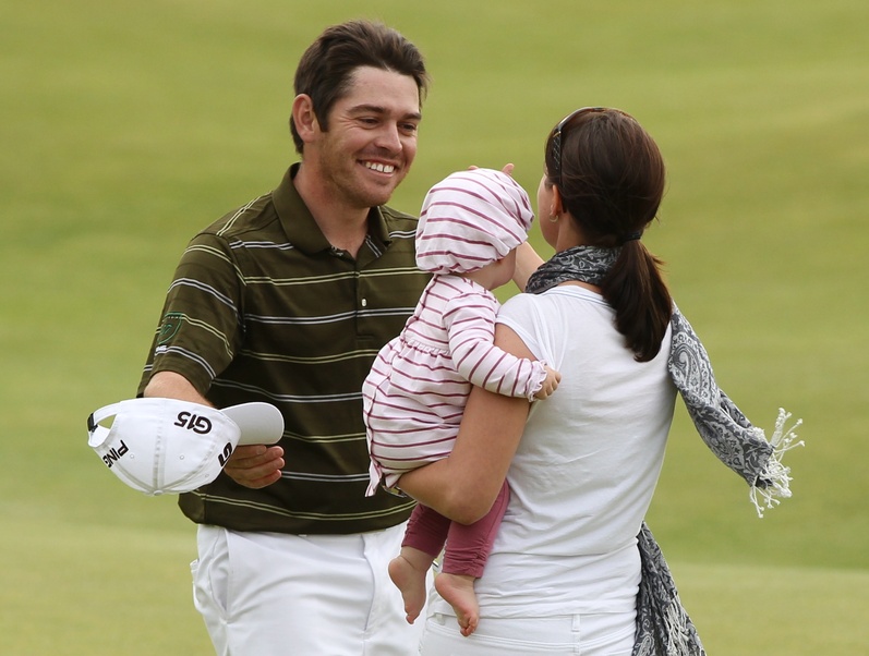 South Africa's Louis Oosthuizen celebrates on the 18th green with his wife Nel-Mare and baby after winning the British Open Golf Championship on the Old Course at St. Andrews, Scotland today