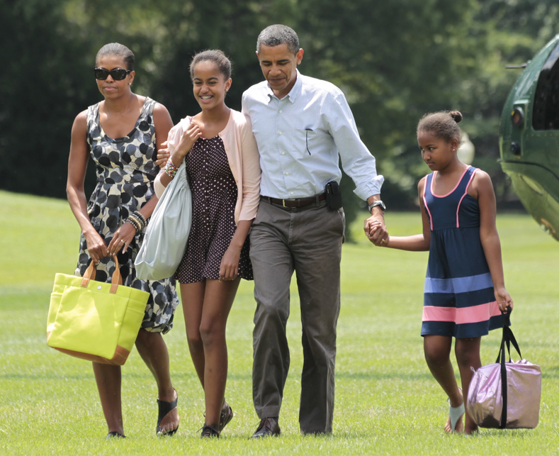 President Barack Obama, second right, first lady Michelle Obama, left, and their children Sasha and Malia Obama, second left, arrive on the South Lawn of the White House in Washington today after a weekend vacation on Mount Desert Island in Maine.