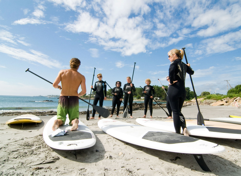 Nico Evans, an instructor with Liquid Dreams Surf Shop in York, kneels as he instructs a class on foot positioning before heading into Cape Neddick Harbor to stand-up paddle.