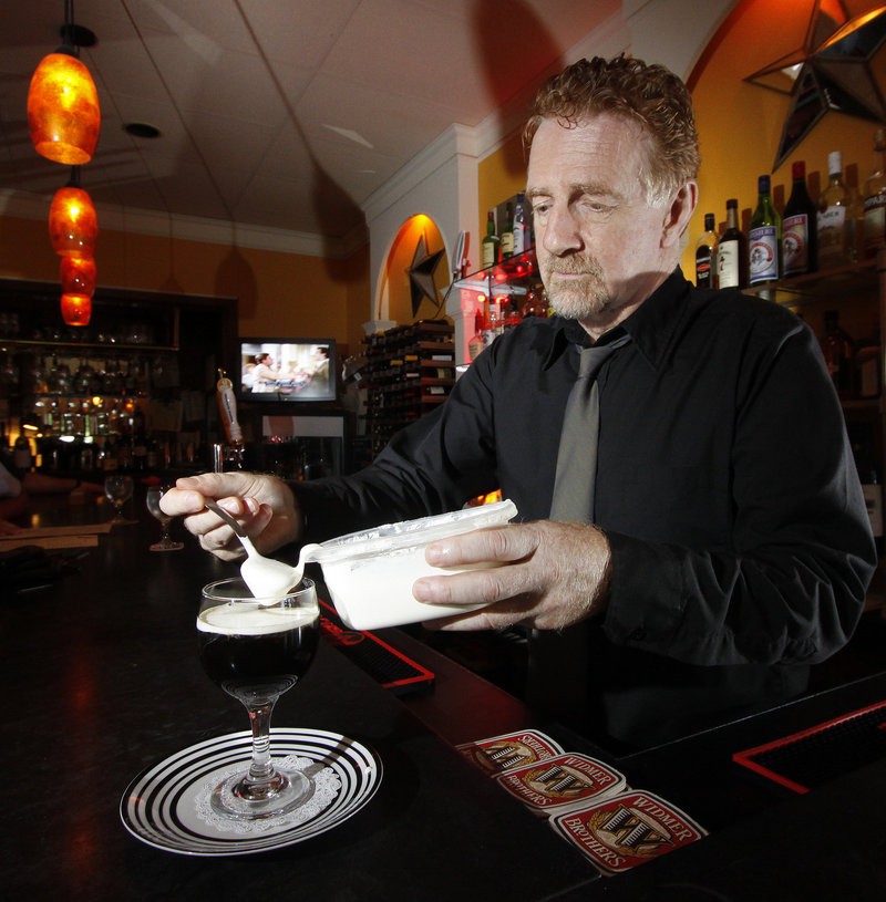 Johnny Robinson, proprietor of Johnny’s Bistro & Bar in Falmouth – and part of its authentic charm – tops off an Irish coffee with lightly whipped cream.