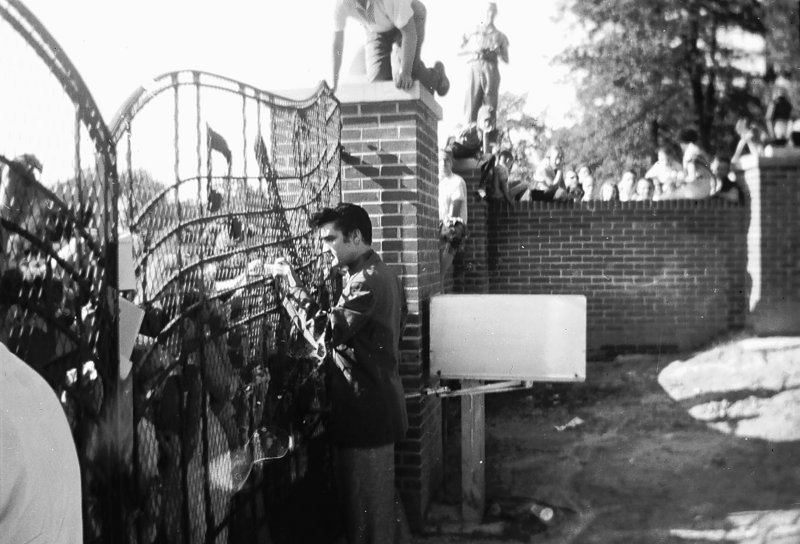 Elvis Presley greets fans at the gates of Graceland in Memphis, Tenn., in 1957 in this previously unpublished photo.