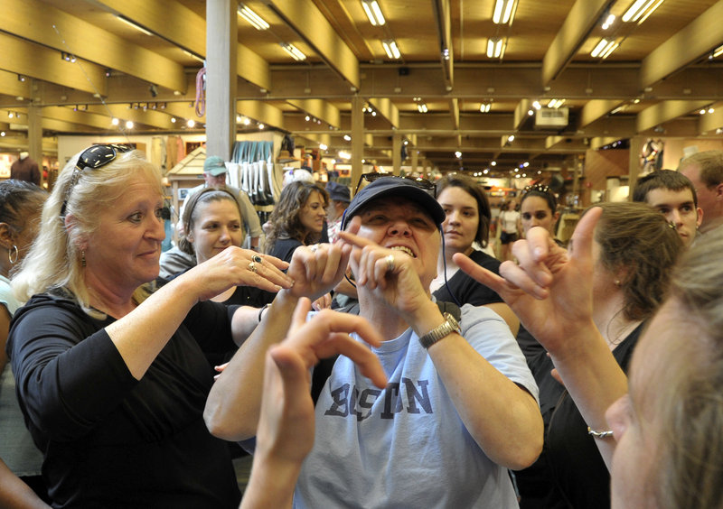 Jane Gammon, left, and others in an interpreting course describe the layout and merchandise at L.L. Bean in Freeport on Thursday for Ona Stewart, who is deaf and blind. They are using American Sign Language close enough for her to understand.