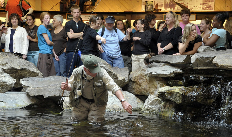 Estes demonstrates the catch-and-release technique in fly fishing for the interpreting program group at Bean’s indoor trout pond.