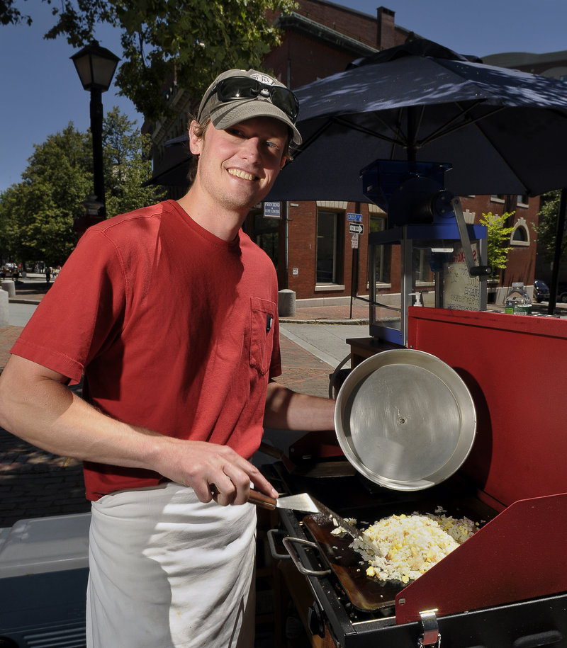 Ben O’Connell heats a special rice dish at the Bazkari lunch cart on Free Street in Portland.