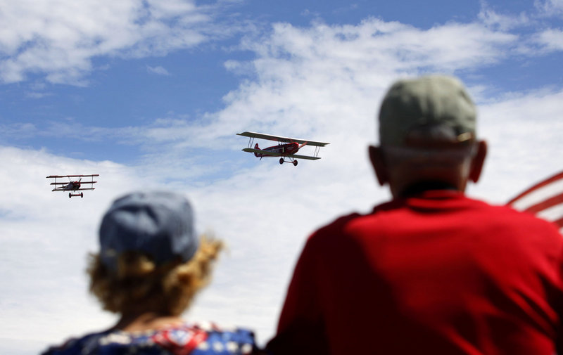 Ruby Barnes of Vassalboro, left, and Claud Daigle of Winslow watch as two Fokker airplanes approach the viewing area. The plane on the right is an original 1923 Fokker C.IV; the one on the left is a 1917 Fokker DR.I reproduction.