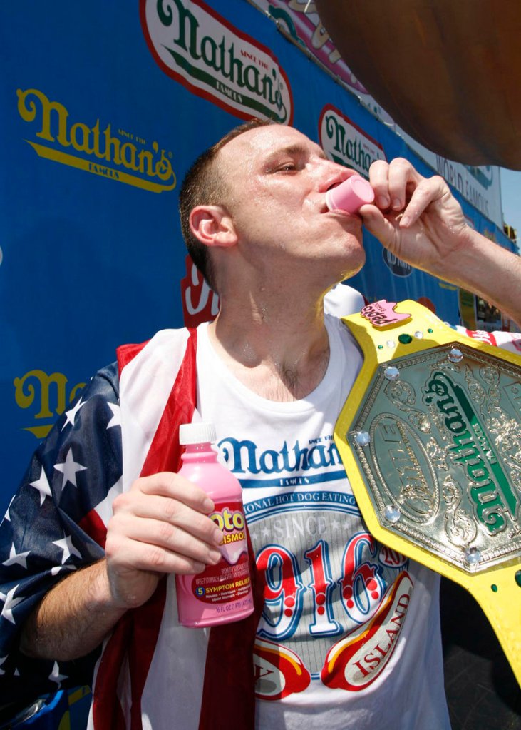Joey Chestnut takes a celebratory swig of Pepto-Bismol after downing 54 hot dogs in 10 minutes to win $20,000 at the annual Coney Island Fourth of July hot dog contest Sunday in Brooklyn, N.Y.