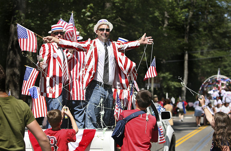 Ocean Park Barbershop Quartet member Mark Andrews gets sprayed with Silly String by his friends Calvin Reddington, left, Andrew Dudley, middle, and Hannah Lanoue, far right, at the conclusion of the 60th annual Independence Day Community Parade in Ocean Park on Monday.