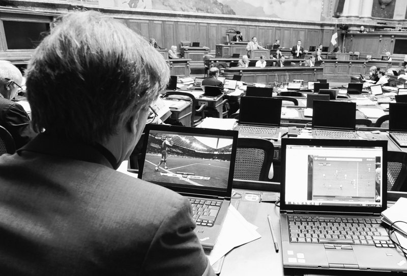 Swiss lawmaker Claude Ruey watches the World Cup soccer match between Spain and Switzerland during a debate in Parliament on June 16. The World Cup only comes around for a month every four years, and there’s no way to keep fans from watching – even during work. Many bosses allow it so they can watch as well.