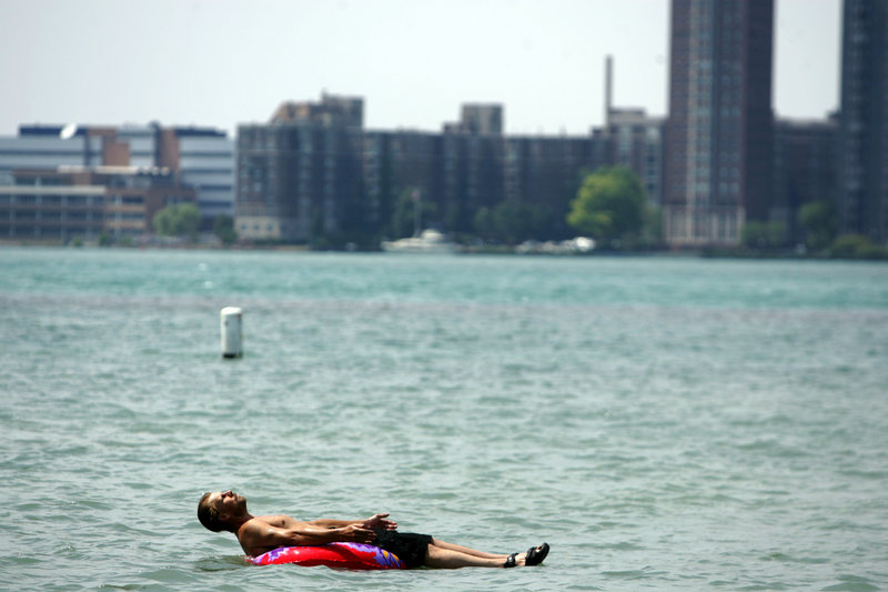Stefan Sidorowicz, 43, of Hamtramck, Mich., floats along the Detroit River off Belle Isle as temperatures climbed above the mid-90s in Detroit on Monday.