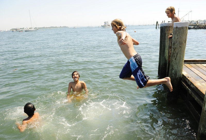 Kamal Kalkhoran, 8, far left, and his brother Kameal, 11, second from left, tread water as Greg Cooper, 12, dives into the Mystic River as Jonathan Cooper, 9, looks on from the Main Street dock in the Groton, Conn., village of Noank, on Monday, July 5, 2010. A string of hot days were expected this week, with temperatures en route to 100-plus degrees in some places. Temperatures reached into at least the 90s Monday from Maine to Texas, into the Southwest and Death Valley. (AP Photo/The Day, Sean D. Elliot) MANDATORY CREDIT; MAGS OUT; INTERNET OUT; NO SALESAP Photo/The Day, Sean D. Elliot