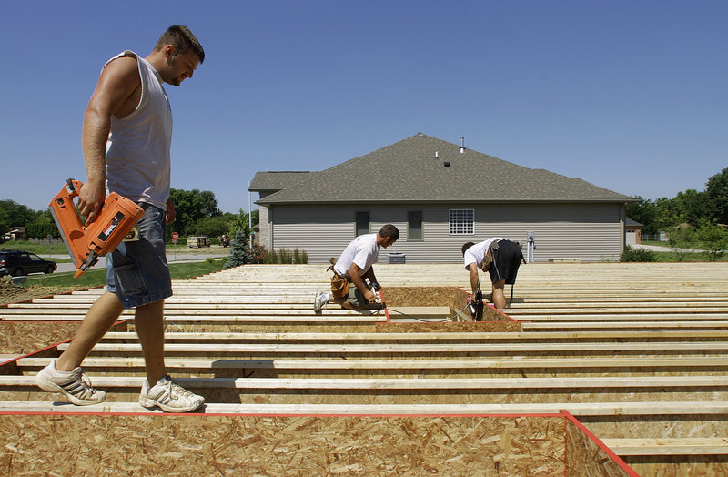 Construction workers Jeremy Jarrard, left, Ryan Turner and Joe Hubbell work on a new home in Springfield, Ill. The service sector grew more slowly in June, an industry group said.