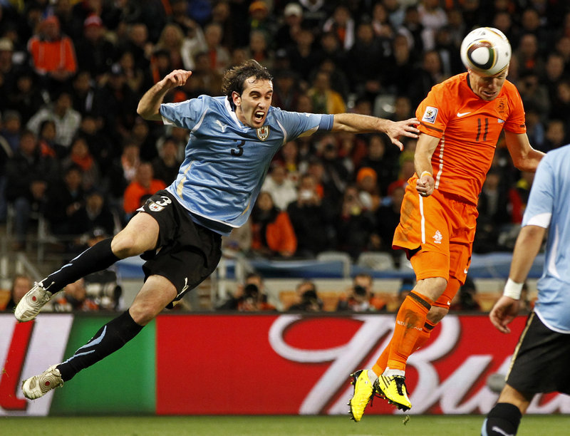 Uruguay’s Diego Godin, left, arrives too late to stop the Netherlands’ Arjen Robben from scoring on a header to give the Netherlands a 3-1 lead Tuesday during a World Cup semifinal in Cape Town, South Africa.