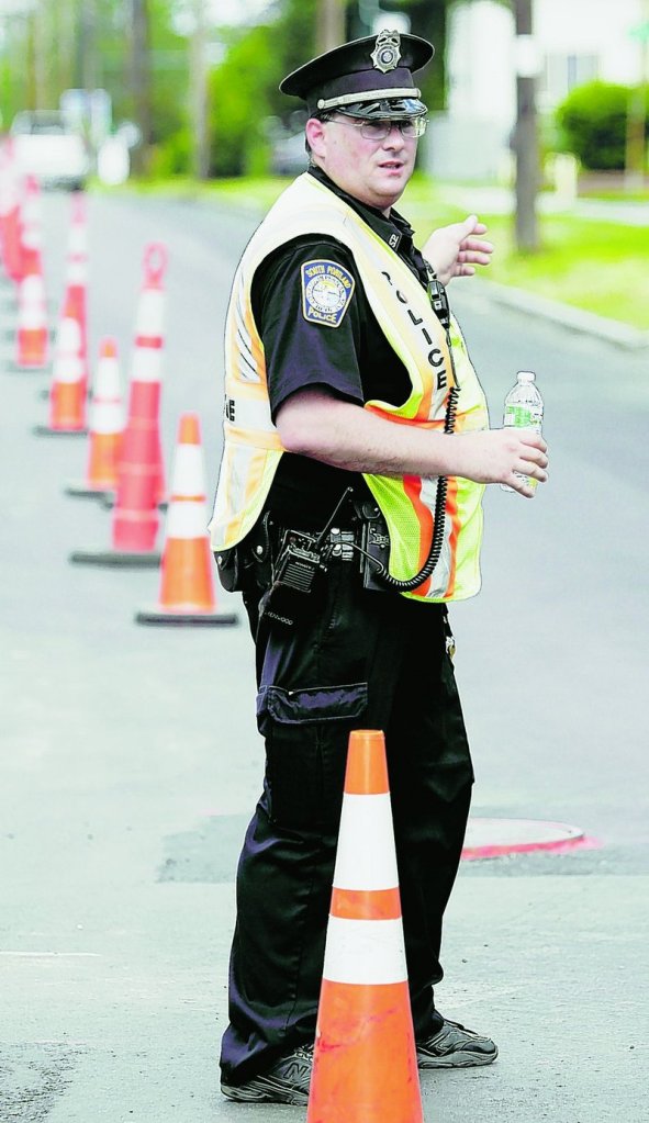 Officer Robert Libby directs traffic around a construction site on Broadway in South Portland on Tuesday.