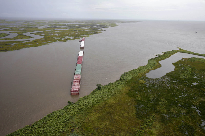 Barges are lined up Tuesday to block oil from the BP spill from flowing through Chef Menteur Pass, which connects the Gulf of Mexico to Lake Pontchartrain. Tar balls from the spill infiltrated the lake last weekend.