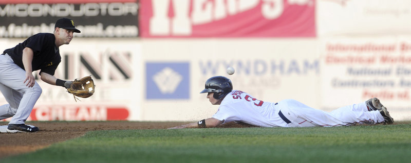 Nate Spears of the Sea Dogs makes a headfirst slide and beats a throw (ball above head) to New Hampshire's Jonathan Diaz to reach second. Spears had four hits in Portland's 11-4 win.