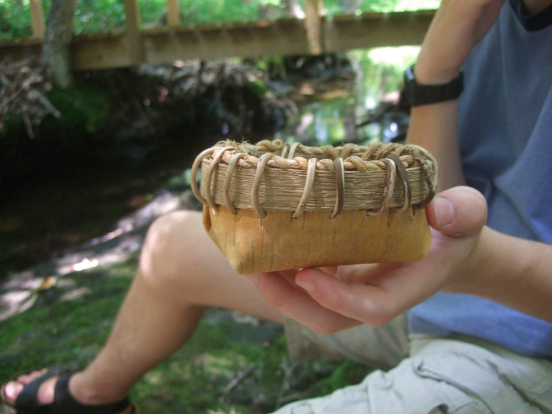 Desmond Molloy holds out his finished birch bark basket.