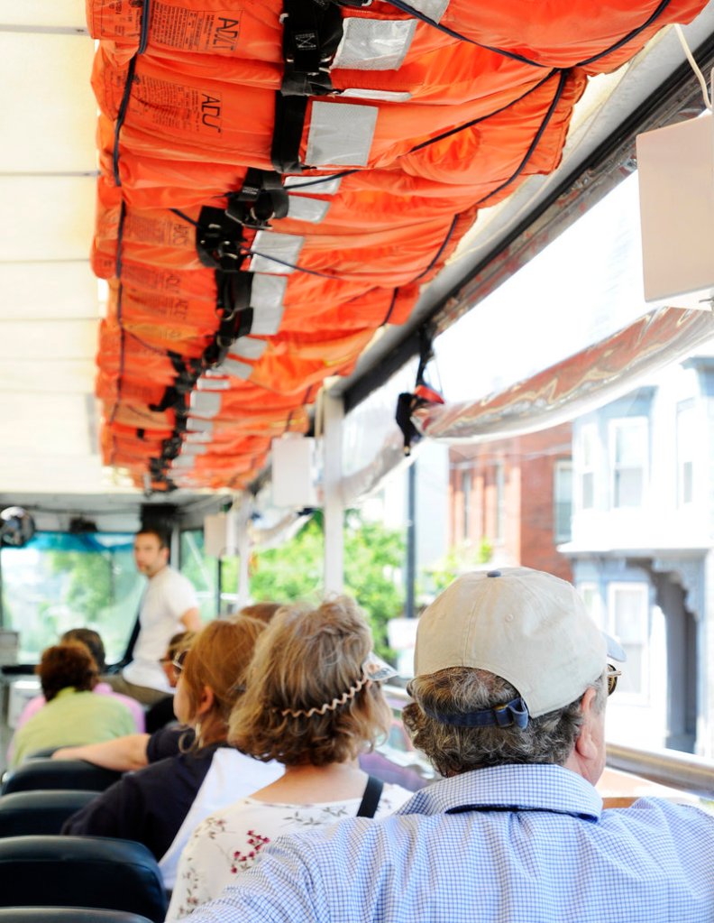 Downeast Duck Adventures passengers sit beneath life vests strapped to the ceiling. The tour of Portland sights takes place on a custom-built amphibious craft.