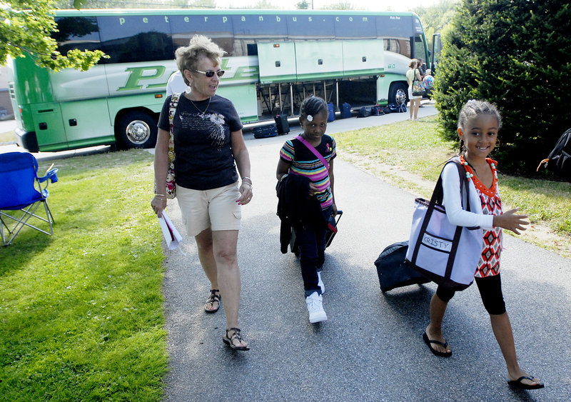 From left, volunteer host mom Barbara Judge of Portland walks with Nadia Grey and Kristina Perez after the Fresh Air Fund kids got off the bus from New York City at Wentworth Intermediate School in Scarborough on Thursday. Maine has 25 host families this summer, all of whom went through an extensive vetting process, coordinators for the fund say.