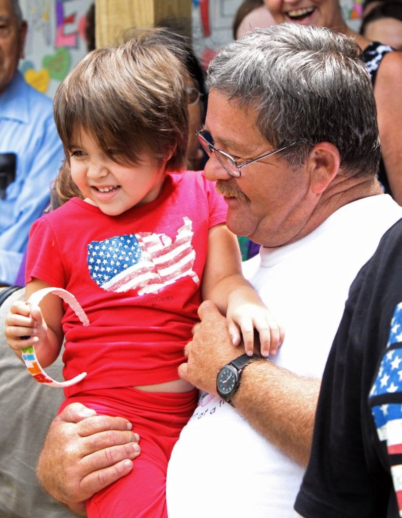 Roy Harrison, right, holds his 4-year-old granddaughter Alisa Maier as she arrives home Thursday in Louisiana, Mo.