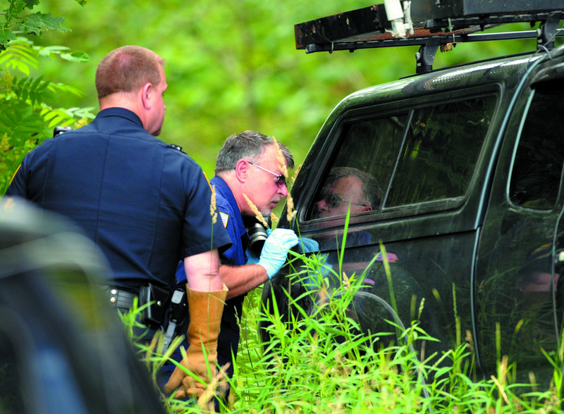Officers look in the back of James F. Popkowski's pickup truck, which was found parked off Route 17 on Thursday.