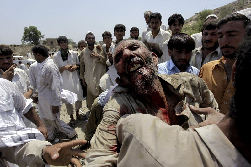 Pakistani villagers carry an injured person after a bombing in a Pakistani tribal area of Mohmand on Friday.