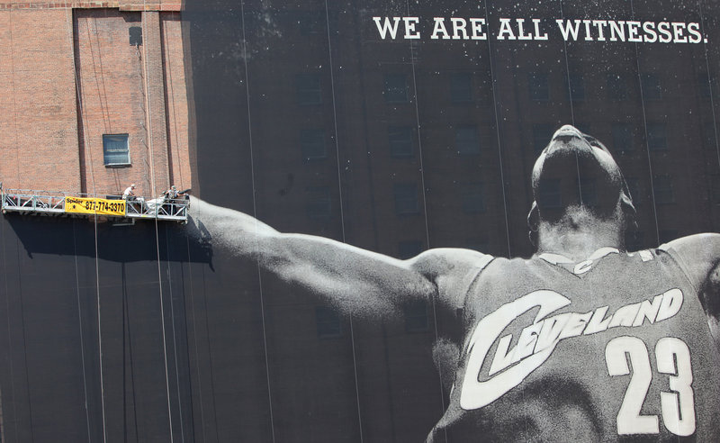 Bringing LeBron Down: Workers dismantle the 10-story-tall image of LeBron James in Cleveland on Saturday. The billboard that has dominated the city’s skyline for years is coming down because the NBA star has left the Cavaliers for the Miami Heat.