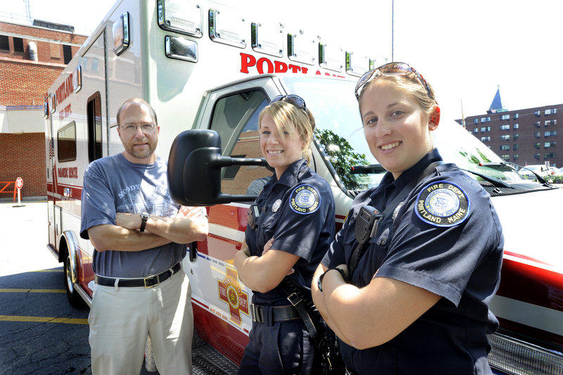 Between answering ambulance calls, reporter Ray Routhier stands with Portland Fire Department paramedics Meagan Letellier, center, and Caroline Harden.