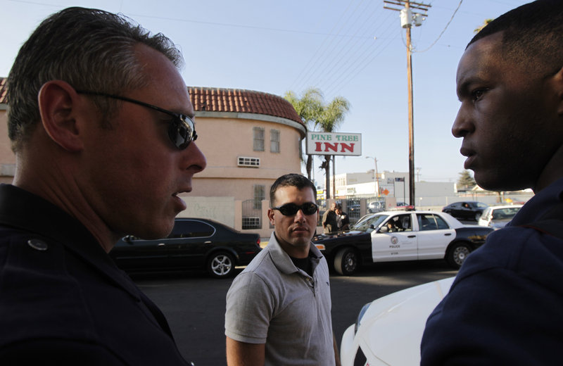 Camp Pendleton Marine Lt. Andrew Abbott, center, and Cpl. Warren Burton, right, listen to Los Angeles police Sgt. Arno Clair during a drug bust in Los Angeles. Abbott is one of 70 Marines who recently patrolled streets with the Los Angeles Police Department for a week.